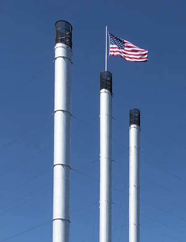 Three Old Mill District smokestacks with the American flag in Bend, Oregon